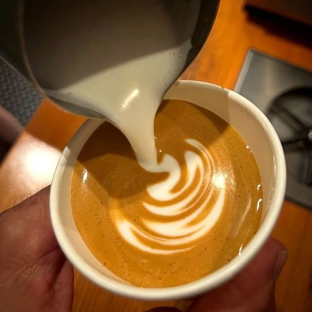 Latte art being poured into a Homeland Cafe cup