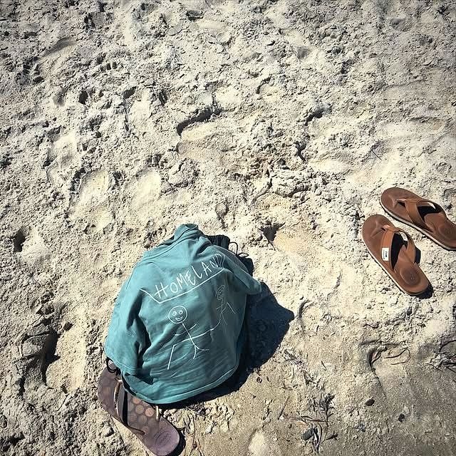 A Homeland Cafe hoodie on the sand at the beach